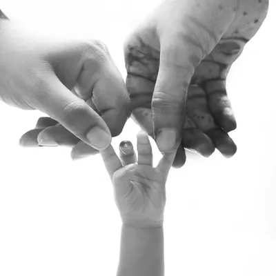 A tiny hand reaching for its parents. This black and white detail shot is a powerful and symbolic representation of family and connection.