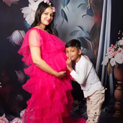 A sweet maternity photo with the older sibling sharing a secret with the baby bump. It's a beautiful way to include the whole family in the excitement.