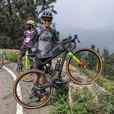 A cyclist enjoying the incredible valley views on our Yercaud tour. This trip covers rolling terrain, challenging climbs, and dense coffee plantations in the Shevaroy hill range.