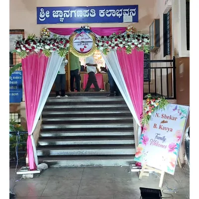A welcoming entrance we designed for an event at Sri Jnanaganapathi Kalabhavana. The decor includes a floral arch with pink and white drapes and a personalized welcome sign for the couple, N. Shekar and B. Kavya.