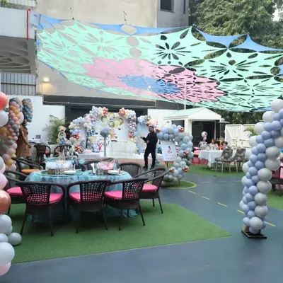 A beautiful overview of our outdoor lawn area decorated for a large birthday party. The colorful canopy provides shade while the ample space allows for seating, decorations, and play areas.