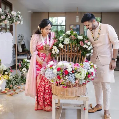 A beautiful moment from Inara's naming ceremony. The new parents admire a basket of flowers, a symbol of the new life and beauty they are celebrating. The decor is soft, pastel, and full of love.
