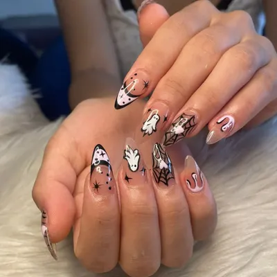 A full view of my custom Halloween nail art. This set features hand-painted ghosts, spiderwebs, moons, and stars on long, clear stiletto extensions for the perfect spooky season look.