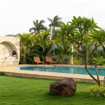 A poolside relaxation nook set against a backdrop of tropical palms and a pristine lawn. This design focuses on creating a private, resort-style oasis in a residential backyard.