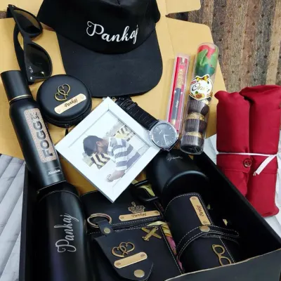 This ultimate gift box has it all. It includes a personalized cap, bottle, wallet, keychain, and eyewear case, plus a watch, photo frame, and other accessories. I can help you build a custom hamper like this based on what he loves.