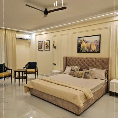 A master bedroom in Rishikesh designed for tranquility. The tufted headboard, warm neutral tones, and classic wall molding create a sophisticated and calming atmosphere with a beautiful view.