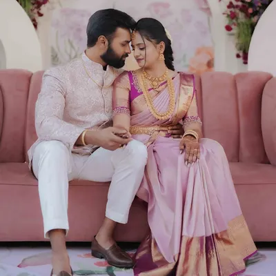 A tender moment between the newly engaged couple, seated on a pink sofa surrounded by beautiful floral decor. This is the kind of serene portrait I love to create.
