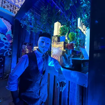 A member of our team in a themed mask, ready to create a unique and mysterious bar experience for your guests.