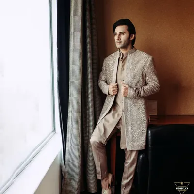 A classic portrait of the groom looking out the window, lost in thought before the ceremony. This shot captures a moment of quiet anticipation and his sharp style.