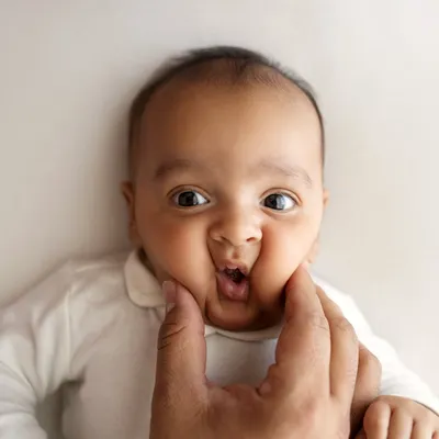 Those squishy newborn cheeks are my favorite! A playful pinch from dad brings out the cutest expression. These are the fun, memorable shots we capture during a newborn session.