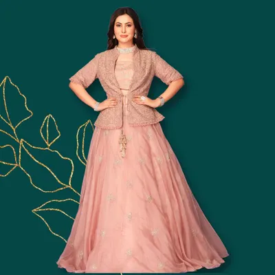 What's trending? This beautiful indo-western attire. A blush pink lehenga paired with a matching embroidered peplum jacket for a chic, modern look.