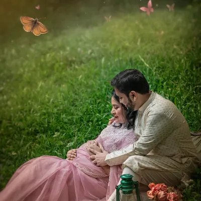 An intimate maternity moment in a sun-dappled meadow. The expecting couple is surrounded by a magical flutter of butterflies, creating a truly romantic and ethereal portrait.