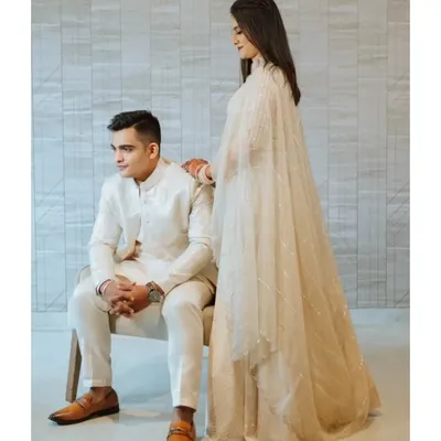An elegant, minimalist portrait of the couple in coordinated all-white outfits. This clean and modern style creates a timeless and sophisticated look for engagement photos.