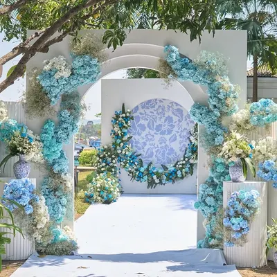 The entrance to this French-inspired carnival featured a grand floral arch in shades of blue and white. The design, with its clean lines and abundant hydrangeas, set a fresh and welcoming tone for the daytime celebration.