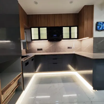 This is a full view of a U-shaped modular kitchen I completed. The design uses a combination of wood-laminate overhead cabinets and matte grey base cabinets, with profile lighting along the floor to add a modern touch.