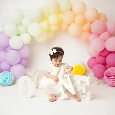 A candid moment from a first birthday shoot, as the little girl plays with the 'ONE' letters. I love capturing these moments of discovery and play.