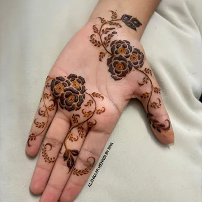 A very elegant and contemporary design featuring a delicate floral vine that gracefully flows across the palm and fingers.