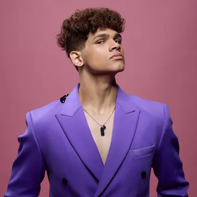A vibrant and modern beauty shot for a Matrix hair campaign. The bold purple jacket and pink background create a high-energy look, while the focus remains on the model's sharp, contemporary hairstyle.