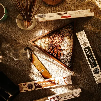 A cozy, sunlit flatlay of aromatic incense sticks and resins on a textured jute mat. This lifestyle shot creates a warm and calming atmosphere, perfect for wellness and home fragrance brands.