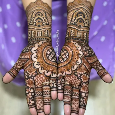 A classic full-hand bridal design featuring architectural dome motifs on the wrists and a beautiful central mandala on the palm. The fingers are detailed with complementary patterns for a complete look.