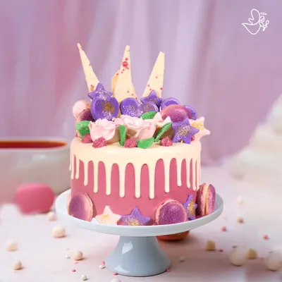 A dreamy and romantic cake for Vanya and Paarth's anniversary in Kalkaji. This pink drip cake is adorned with macarons, edible glitter, and white chocolate shards for a touch of modern luxury.