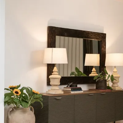 In this passageway, I created a moment of quiet elegance. A distressed wooden mirror is paired with a sleek, fluted sideboard for shoe storage, while twin lamps provide warm, ambient lighting. The mirror reflects the staircase wallpaper, subtly connecting different areas of the home.