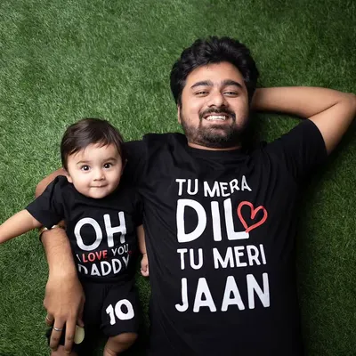A fun and creative shot of a father and son in matching t-shirts. This overhead photo on a green turf background is playful and shows a lot of personality.
