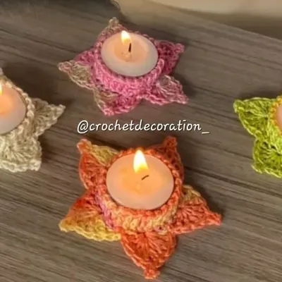 Our star-shaped crochet tea light holders, shown here in various colors with lit candles. They create a warm, festive glow and are perfect for celebrations like Diwali.