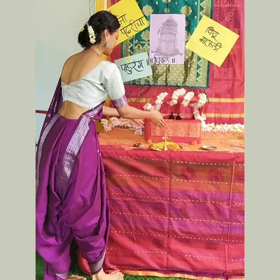 Dressed in a traditional Nauvari saree, I am preparing the puja setup for our Ashadhi Ekadashi celebration. It is important for me to share these beautiful cultural practices with the children.