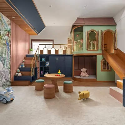 A wide view of the Prata House play area, showing the custom-built playhouse with a slide, integrated storage, and a jungle-themed wallpaper. The entire space is a colorful haven designed to spark imagination.