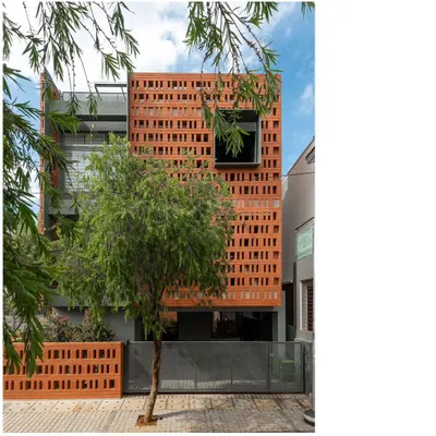 The defining feature of the 'Big-Little House' is its perforated brick facade. This screen provides privacy for the service areas located at the front while allowing for natural ventilation and creating a unique, textured architectural identity.