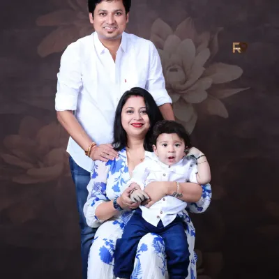 A classic family portrait with mom, dad, and their little one. Coordinated outfits and a simple, elegant backdrop ensure that the focus remains on the family's connection and happiness.