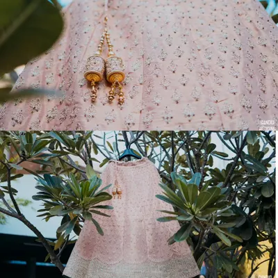 A focus on the exquisite details of a bridal lehenga, from the delicate embroidery to the elegant tassels (latkans), hung beautifully in a natural setting.