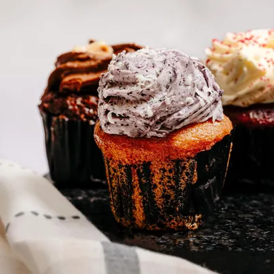 A mouth-watering close-up of a cupcake, focusing on the creamy frosting and rich texture. This type of shot is designed to trigger appetite and drive sales.
