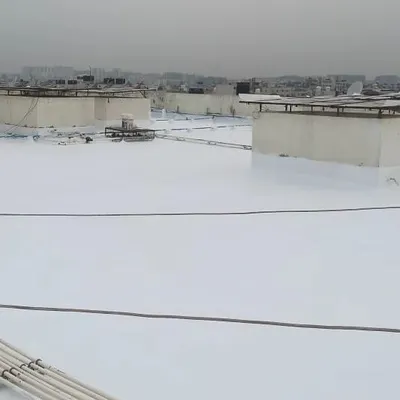 A finished terrace with a bright white, heat-reflective waterproof coating. This seamless application not only stops leaks but can also help in reducing heat absorption, keeping the rooms below cooler.