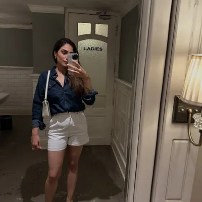 A classic summer look featuring a dark denim shirt and white shorts. This is a simple, no-fuss outfit perfect for a casual day out.