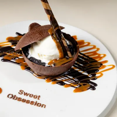 Surrender to our signature "Death by Chocolate" dessert. A rich chocolate dome melts to reveal creamy vanilla ice cream, all drizzled with chocolate and caramel sauce. It's pure indulgence.