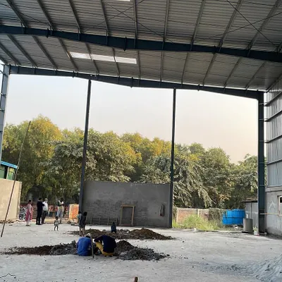 The vast, open interior of a Pre-Engineered Building (PEB) under construction. These steel structures are ideal for industrial applications, offering strength, durability, and a clear span for maximum usable floor space.