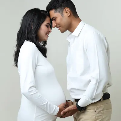 A classic and intimate pose, with the couple forehead-to-forehead. This captures the deep connection and shared anticipation in a simple, beautiful way.