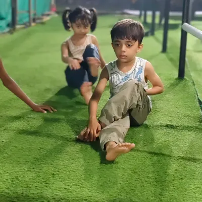 Working on flexibility is just as important as building strength. These young athletes are practicing their stretches on the turf, improving their range of motion.
