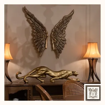 This powerful decorative set features a stalking golden panther and dramatic angel wings in a burnished gold finish. Placed on a console, these metal art pieces create a bold and luxurious statement.