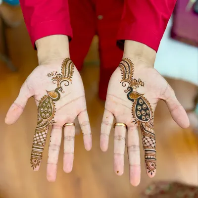 A stylish and simple mehendi design for the groom, featuring matching peacock motifs.