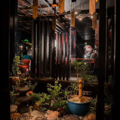This indoor Zen garden, created for Arigato restaurant, serves as a tranquil centerpiece. The composition of rocks, a bamboo water feature, and subtle greenery provides a peaceful view that enhances the Japanese dining experience.
