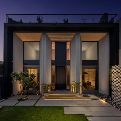 The exterior of the Mr. Light showroom at night, where architectural lighting emphasizes the building's strong vertical forms and creates an inviting, high-end presence.