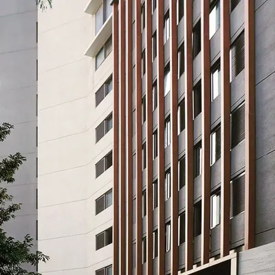 For The Bandra Project, we designed a simple yet practical façade using vertical wooden fins to conceal the parking floors, set against a stone-clad backdrop for a modern aesthetic.