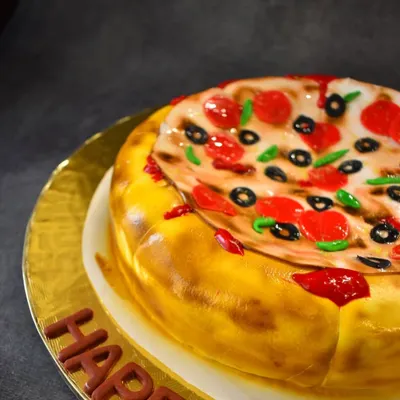 A close-up of the pizza illusion cake, showing the detail of the fondant "cheese," "pepperoni," and "olives." It's a Nutella chocolate chip cake designed to trick the eye and delight the taste buds.
