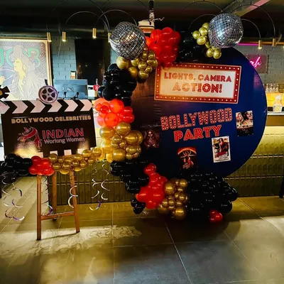Lights, Camera, Action! A fun Bollywood-themed party setup, complete with a film clapboard and a backdrop of movie posters. Themed parties are a great way to add a layer of fun and get guests to dress up.
