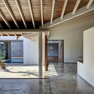 A central courtyard serves as the organizing principle in this design, creating a serene, open-air heart for the building. The polished concrete floors and natural wood ceiling frame the view, blurring the line between interior and exterior space.
