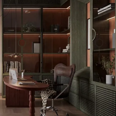 This study is designed as a sophisticated workspace, dominated by deep green custom cabinetry with integrated lighting. The rich, red-toned wood of the curved desk provides a striking contrast, creating a powerful and inviting atmosphere.