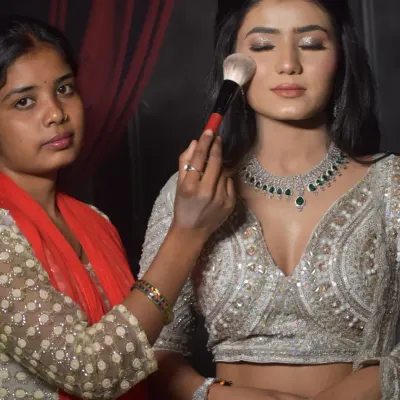 A student from my one-on-one course carefully applies finishing powder to a model's engagement look. This practical session focuses on creating a soft, glowing base that looks perfect in photos.
